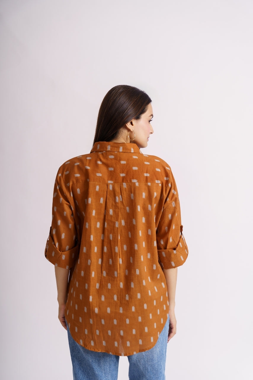 Close-up of ikat print pattern on rust cotton shirt fabric