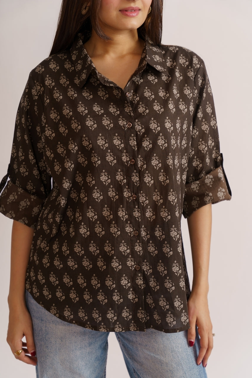 Model wearing oversized brown floral shirt, three-quarter pose