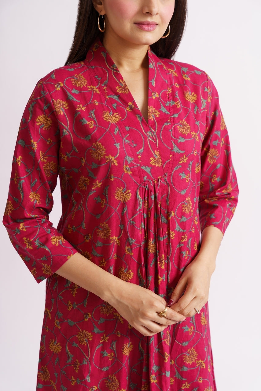 Close-up of vine and floral print on magenta cotton fabric