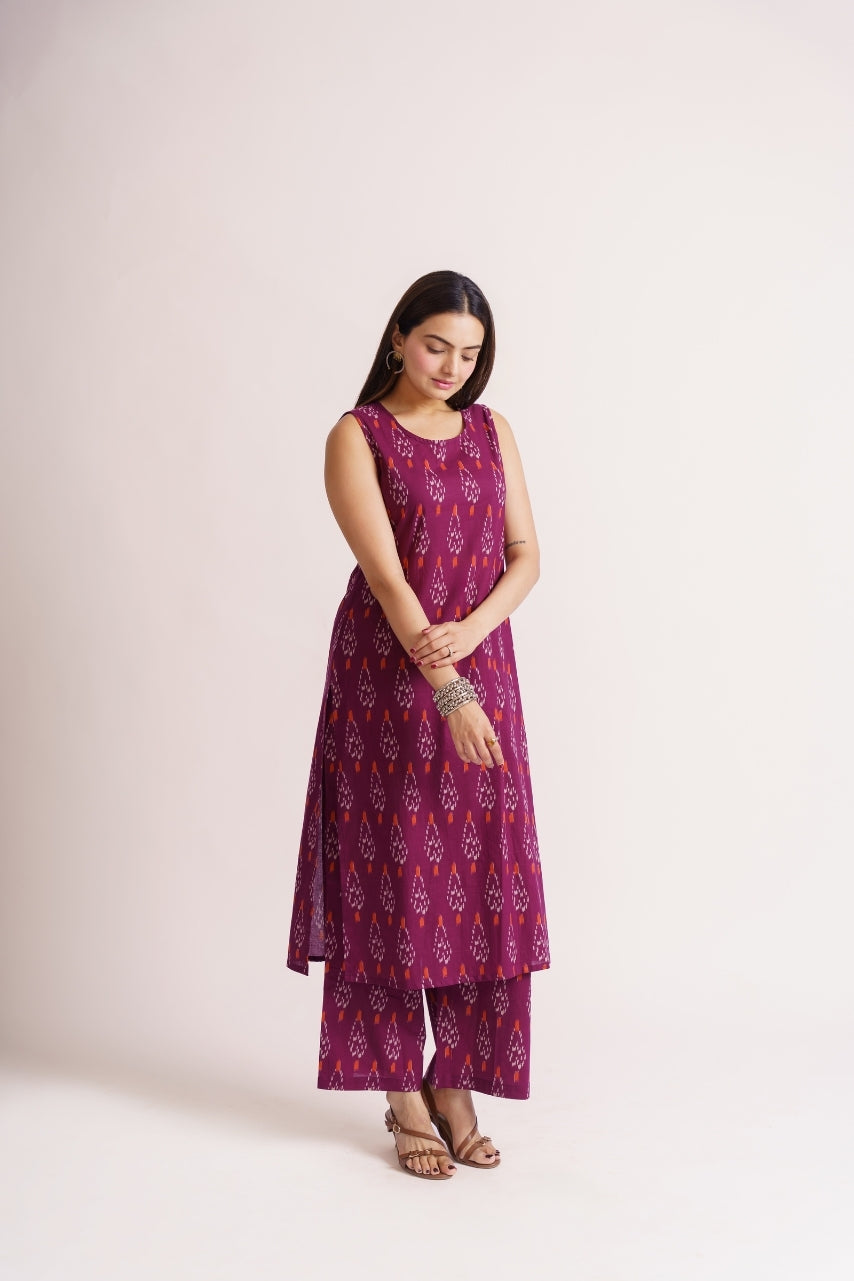 Woman wearing magenta ikat print sleeveless kurta set, front view