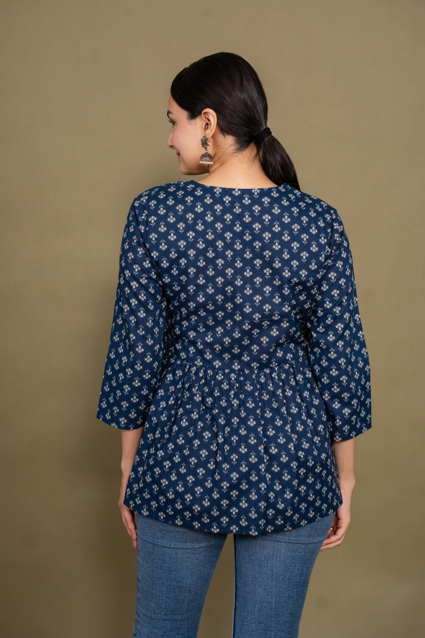 Woman wearing a blue patterned top against a brown background
