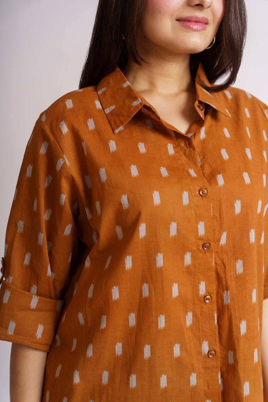 Model wearing oversized rust ikat print shirt, front pose