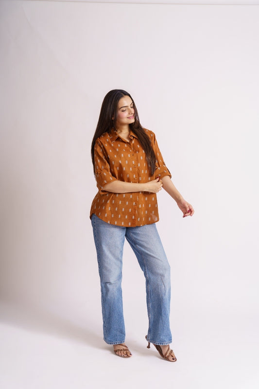 Woman wearing rust ikat print cotton button-down shirt with jeans