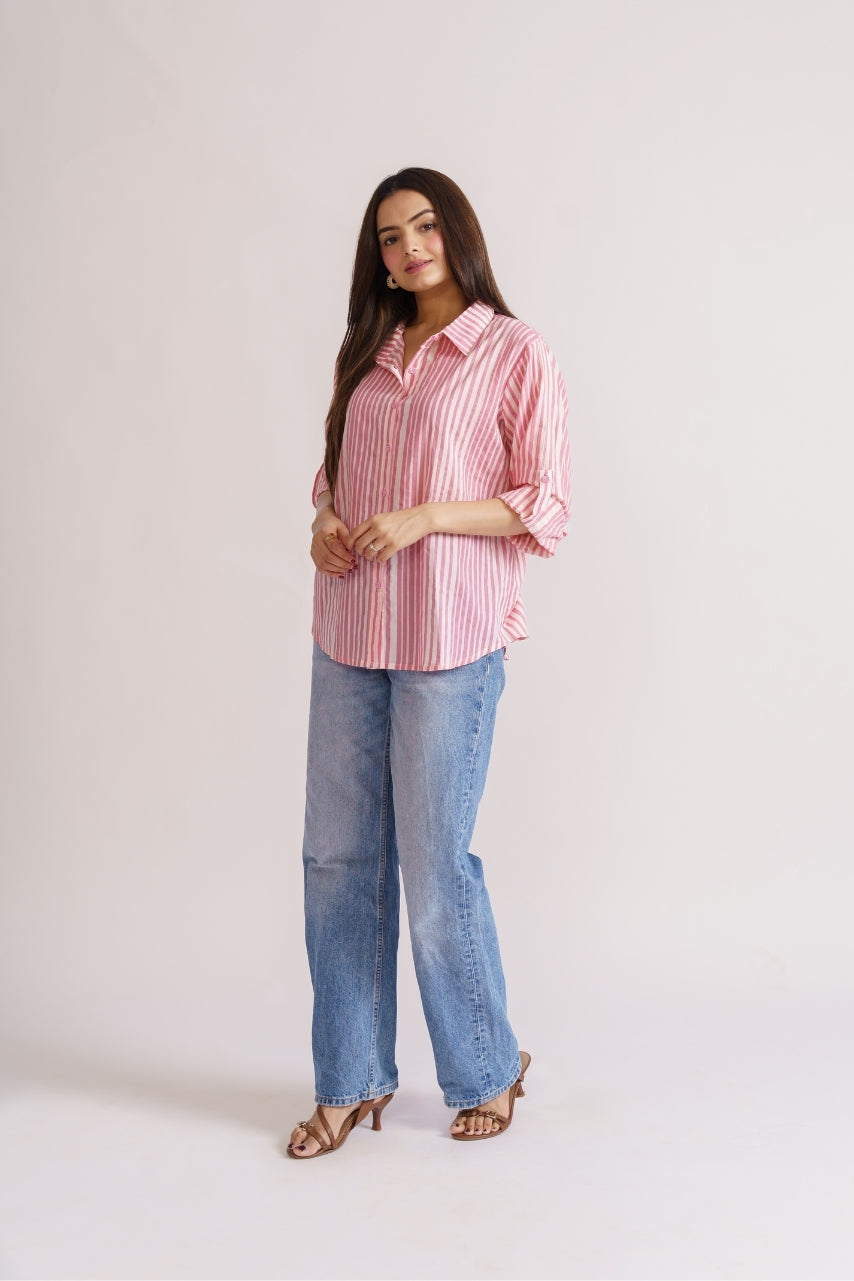 Model wearing oversized pink stripe shirt, side profile pose