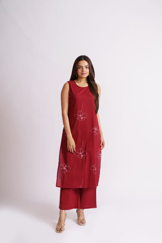 Woman wearing maroon line floral print sleeveless kurta set, side view