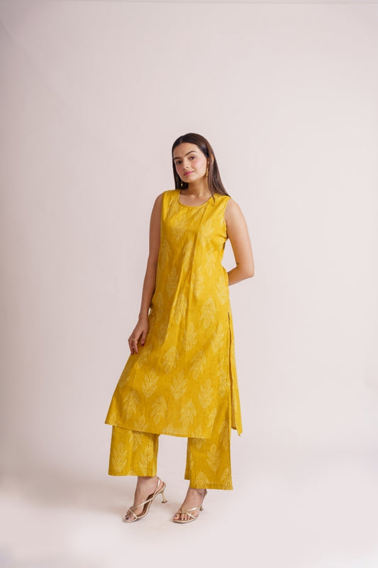 Woman wearing yellow leaf print sleeveless kurta palazzo set, front view